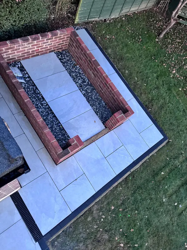 New brick raised bed set into a porcelain patio