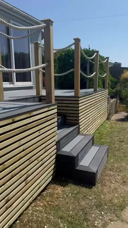 Raised composite deck with steps, slatted timber cladding and rope handrail