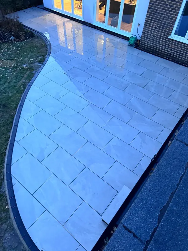 Curved porcelain patio edge meeting the lawn