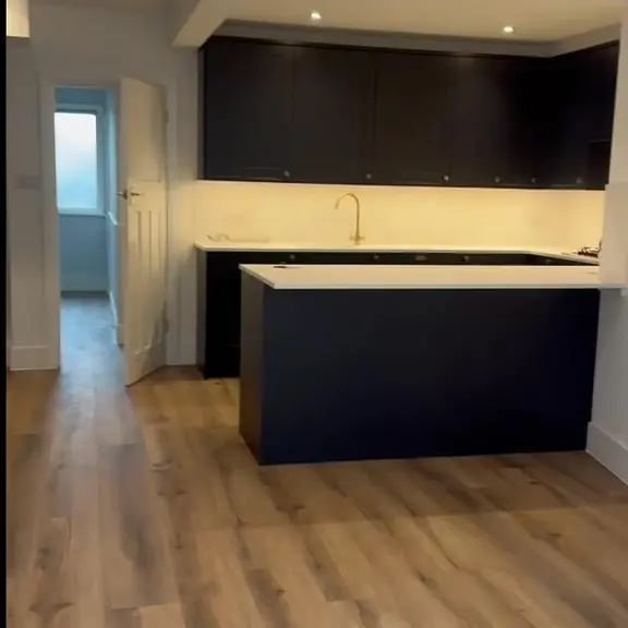 Navy shaker kitchen with island and wood-effect floor in a new extension