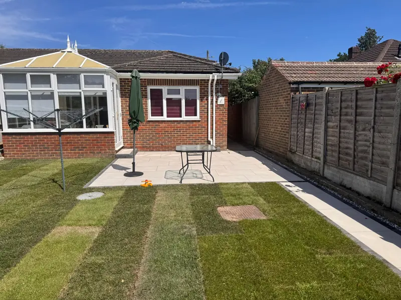 Back garden of a bungalow with a new patio and freshly laid lawn