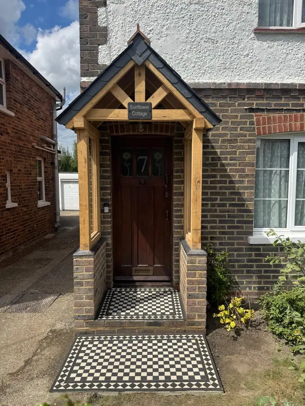 Oak-framed porch with a black and white tiled path, seen from the front