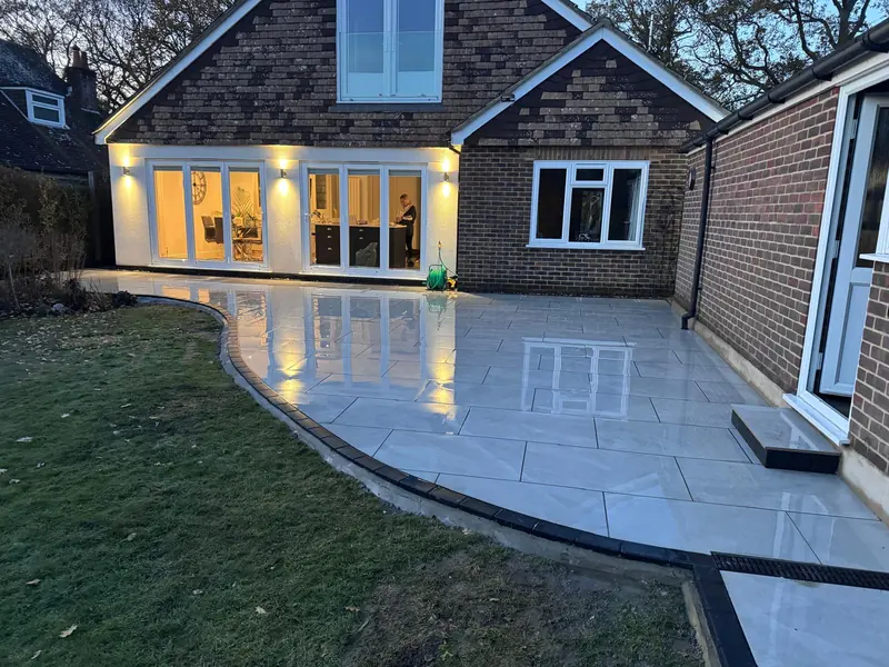Porcelain patio with outdoor lights along the back of a house